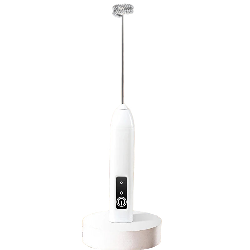 White handheld electric milk frother on a beige background